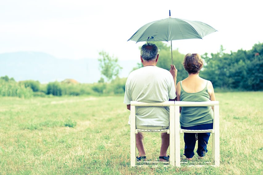 Retirees sitting under an umbrella