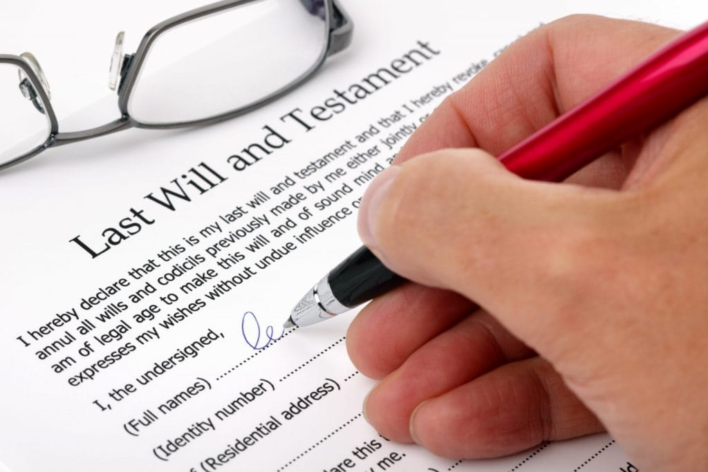 A will being signed and dated to confirm it is accurate.