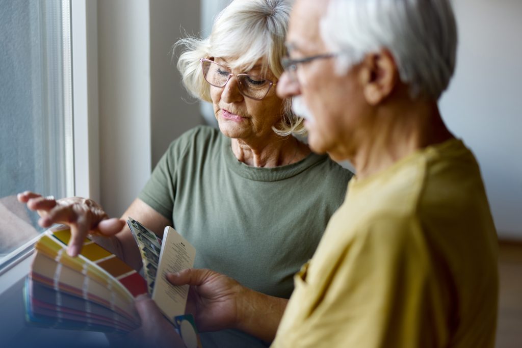 Couple choosing colours to re-decorate, funded by equity release