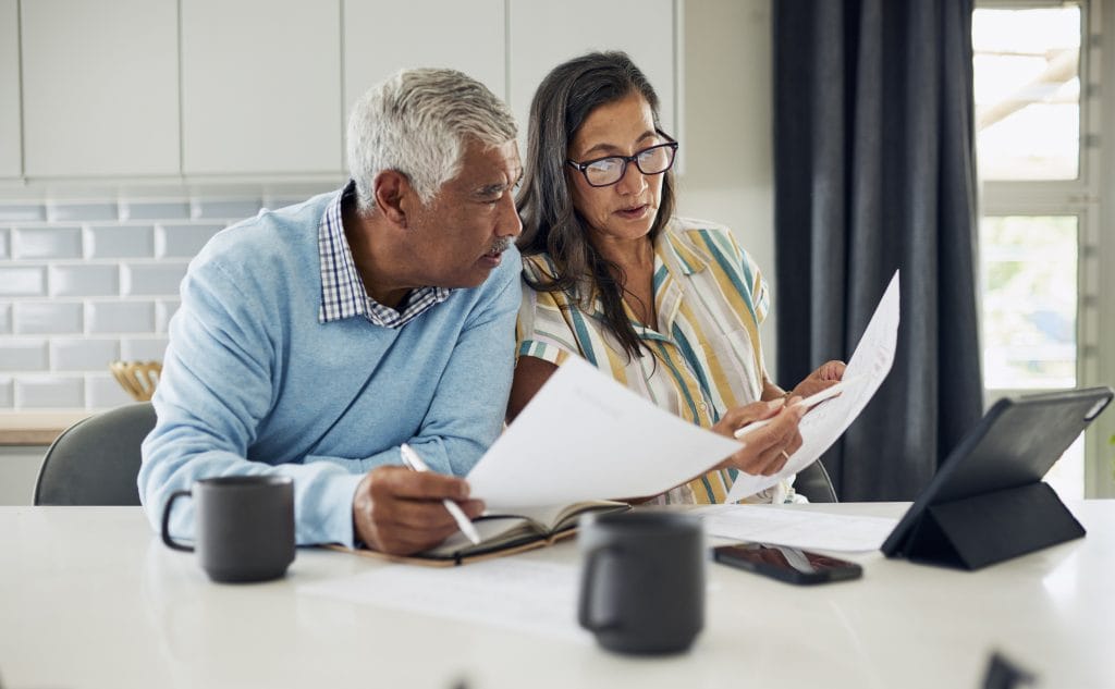 couple planning for retirement by reviewing their outgoings and options to boost their retirement income.